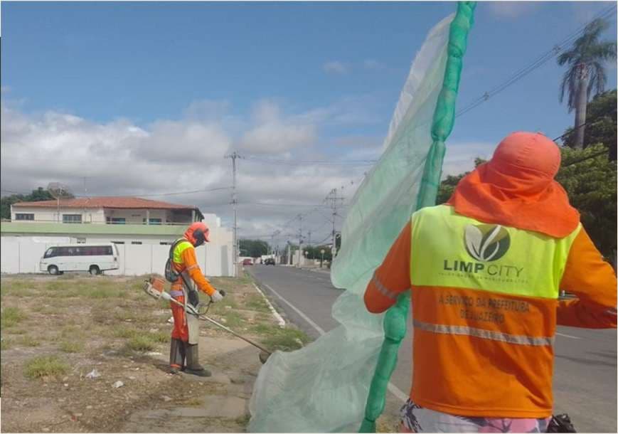 Agente da Limp City com colete identificado fazendo roçagem mecanizada à beira de via, a serviço da prefeitura de Juazeiro